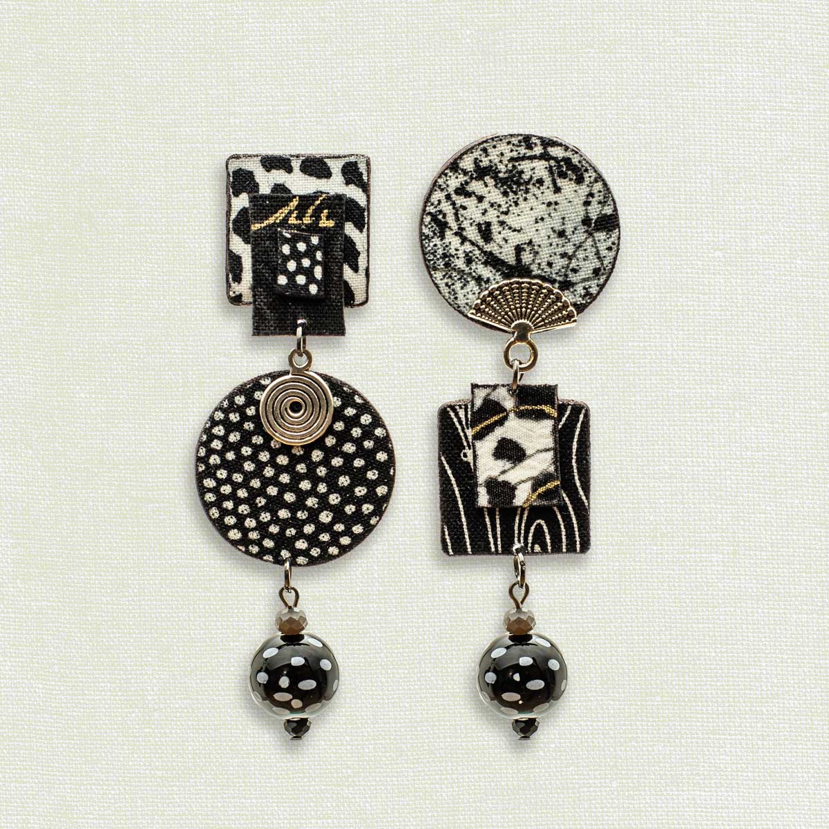 Asymmetric 3 tiered earrings, hand painted by artist Suzanne Bellows for SuzanneBellowsJewelry.com. This pair is part of the Graphic Collection and features bold black and white patterns.