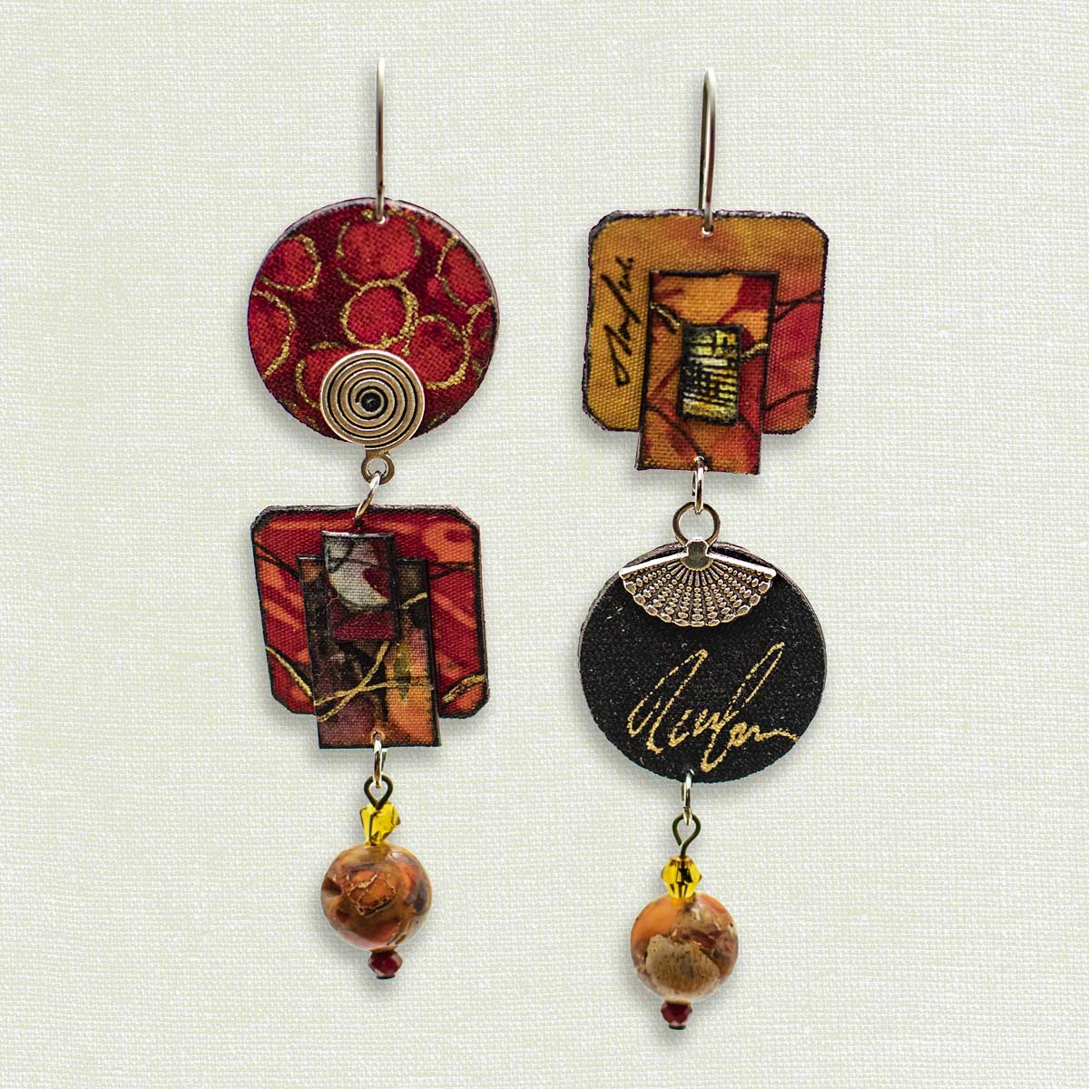 Asymmetric 3 tiered earrings, hand painted by artist Suzanne Bellows for SuzanneBellowsJewelry.com. This pair is part of the Earth Collection and features reds, black, silver and gold.